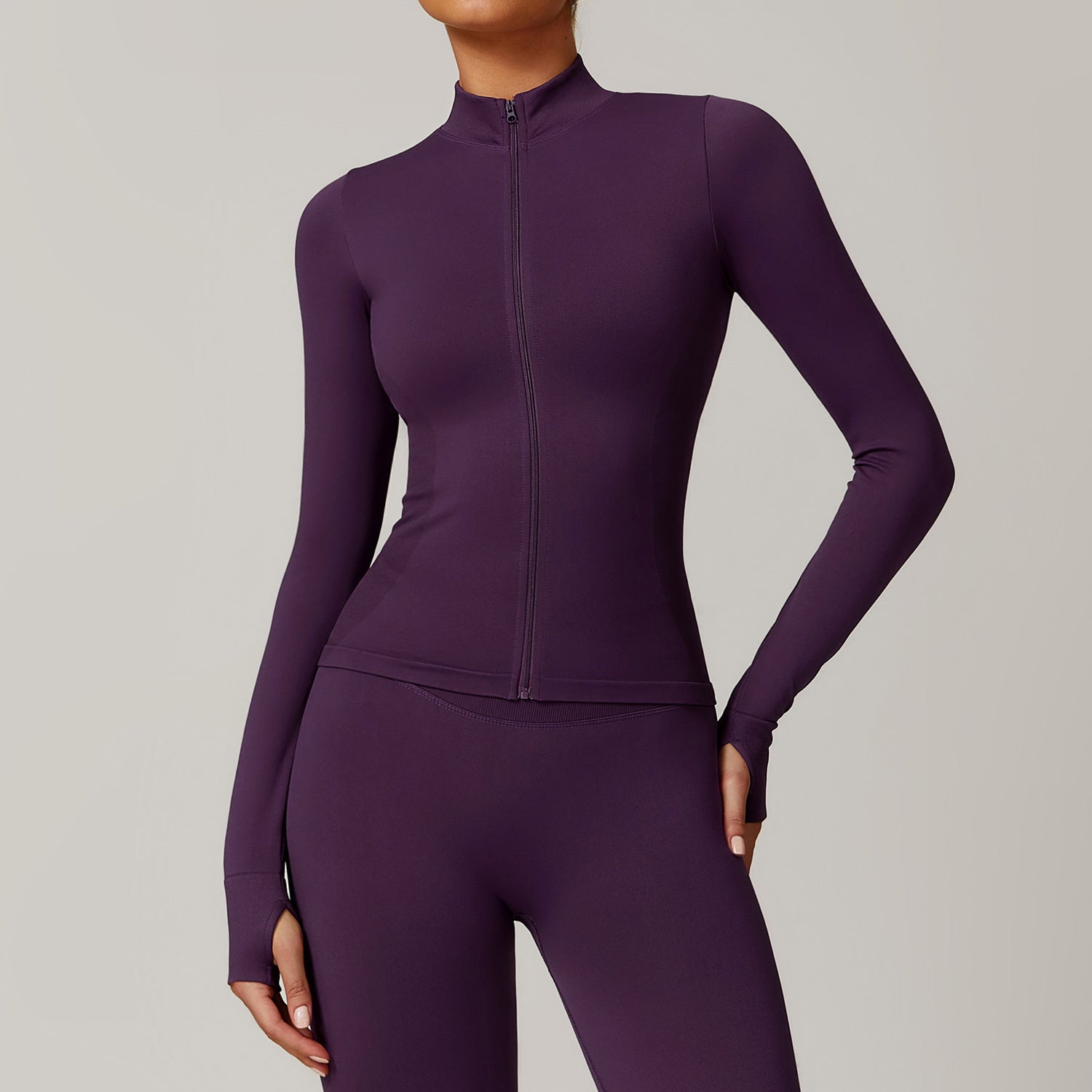 Purple athletic jacket and leggings set on a neutral background