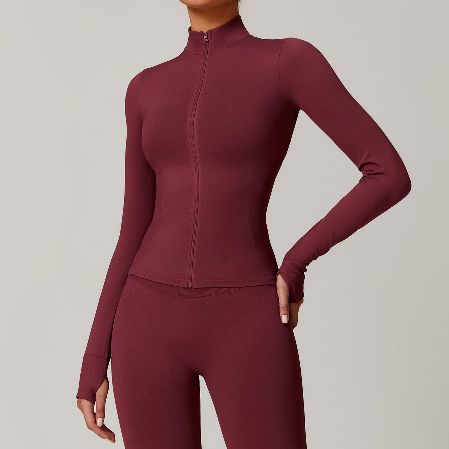 Maroon athletic jacket and leggings set on a neutral background
