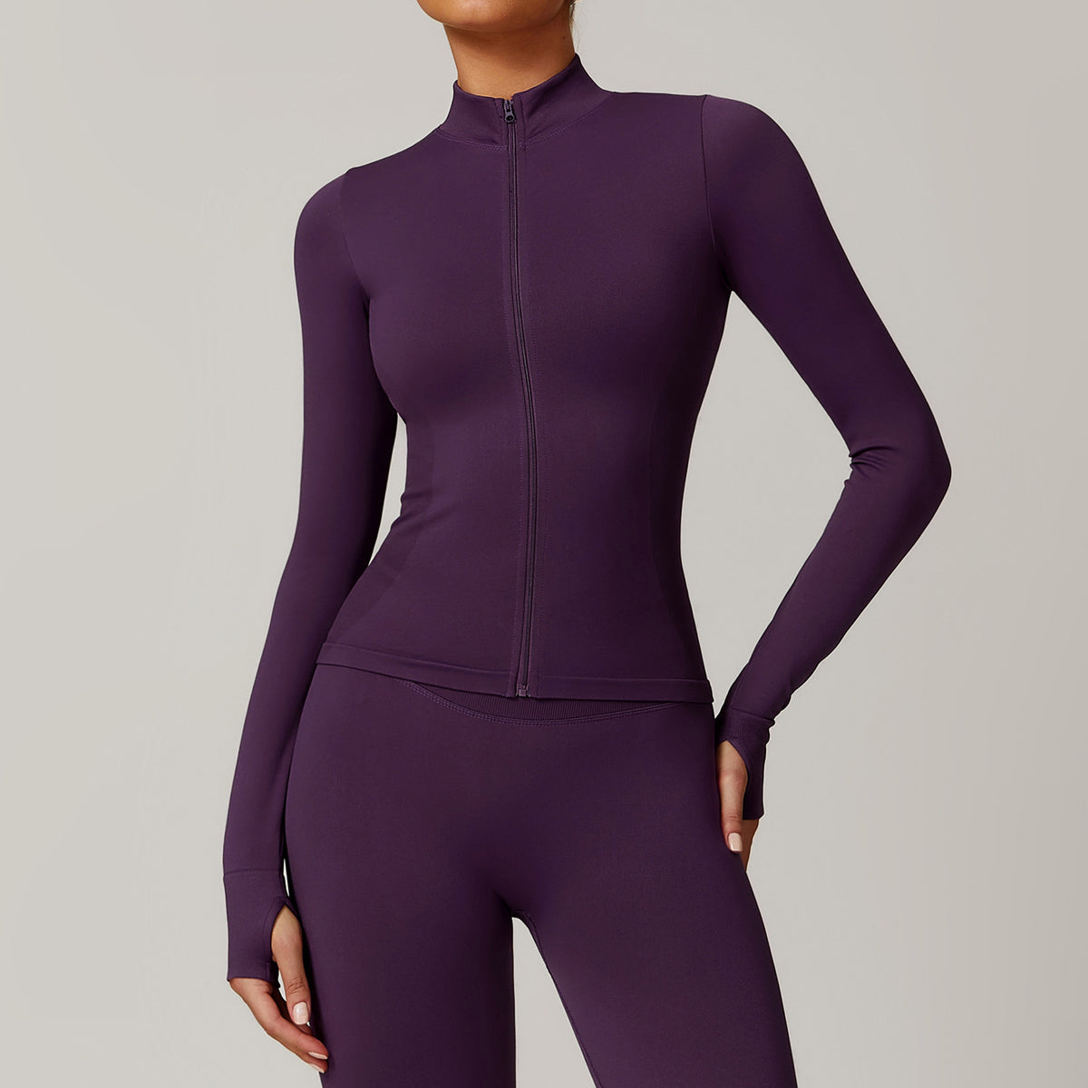 Purple athletic jacket and leggings set on a neutral background